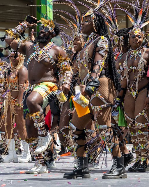 A group of people in colorful costumes are dancing in a parade.