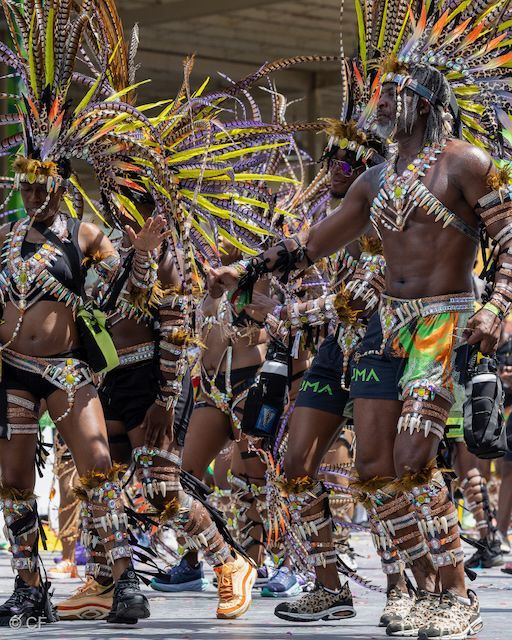 A group of people in colorful costumes are dancing in a parade.