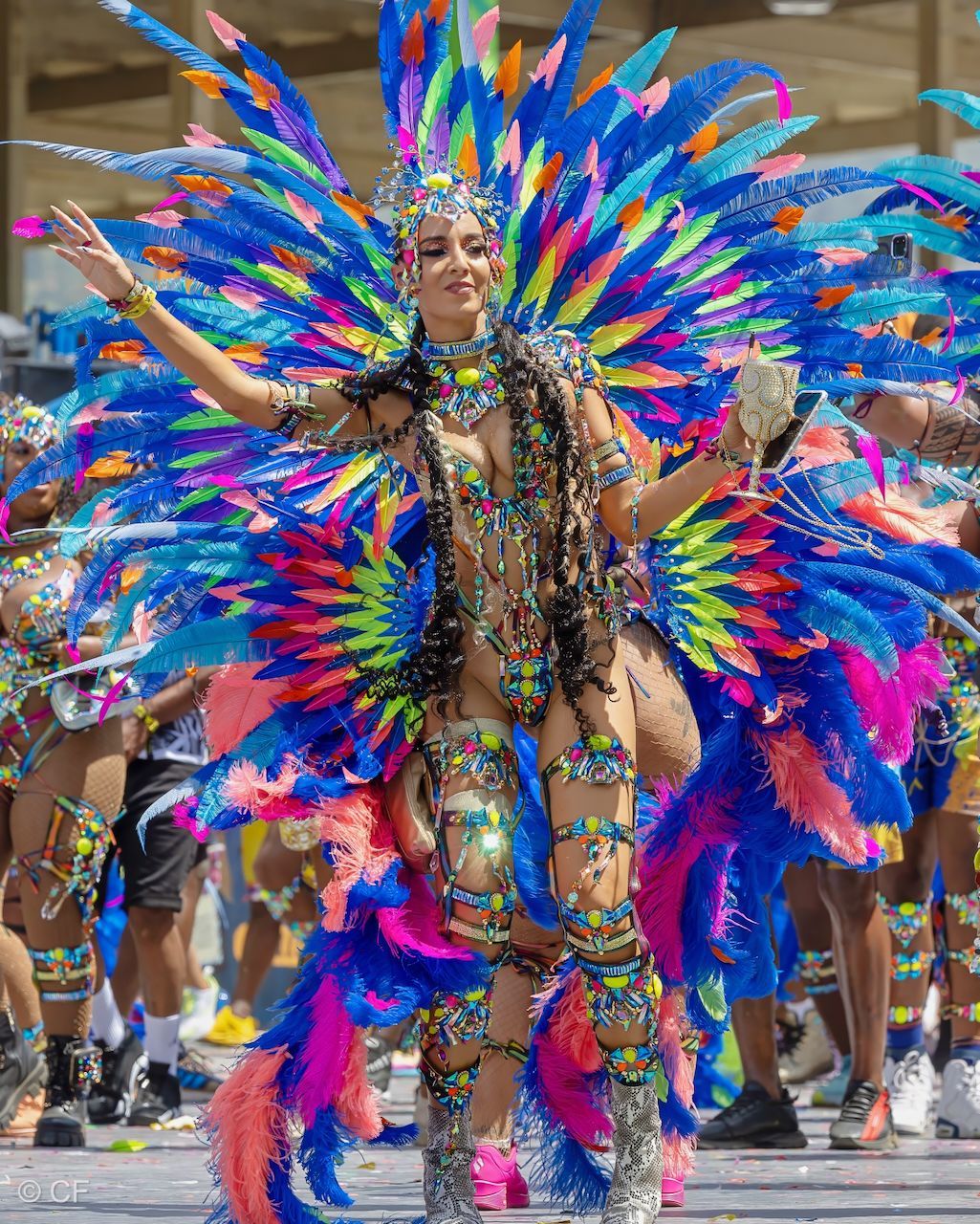 a woman 3 in a colorful costume is dancing in a parade .