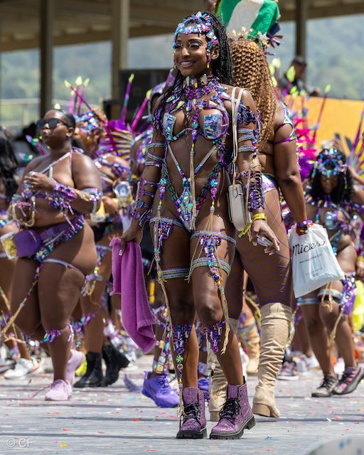 A group of people in colorful costumes are walking down a street.