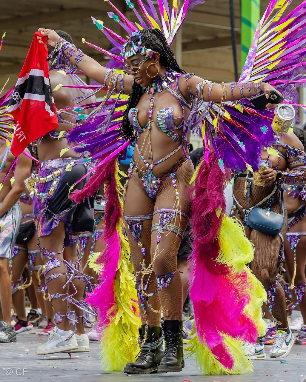 A woman in a colorful costume is dancing in a parade