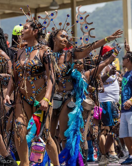 A group of people in colorful costumes are dancing in a parade.