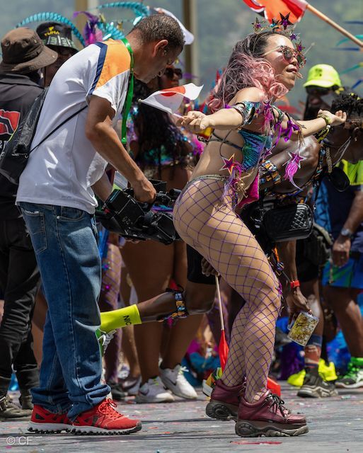 A man is taking a picture of a woman dancing at a carnival.