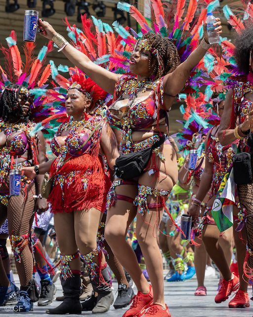 A group of people in colorful costumes are dancing in a parade.