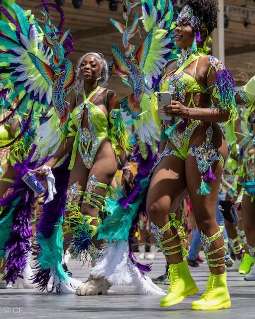 A group of women in colorful costumes are dancing in a parade.