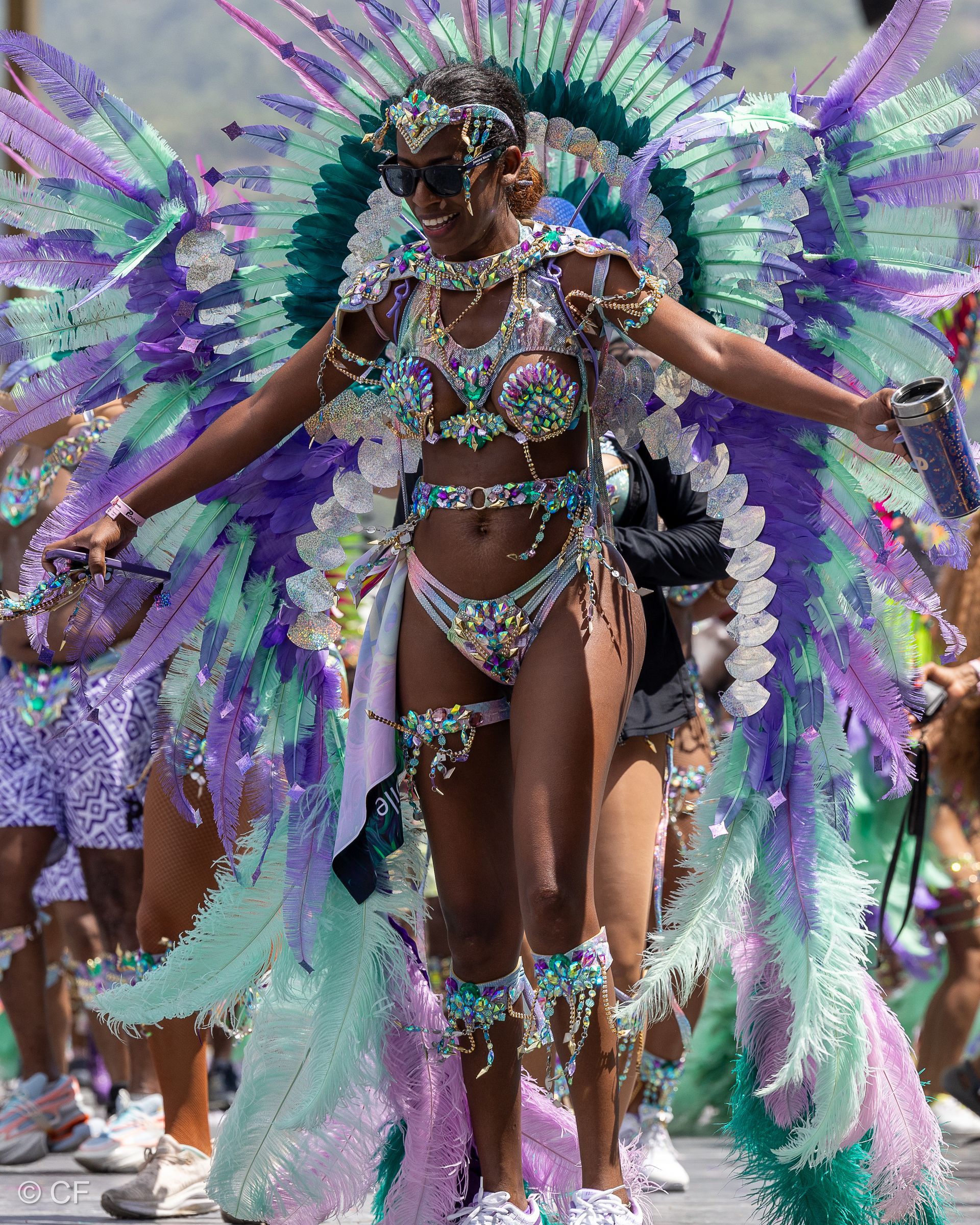 A woman in a colorful costume is dancing in a parade.