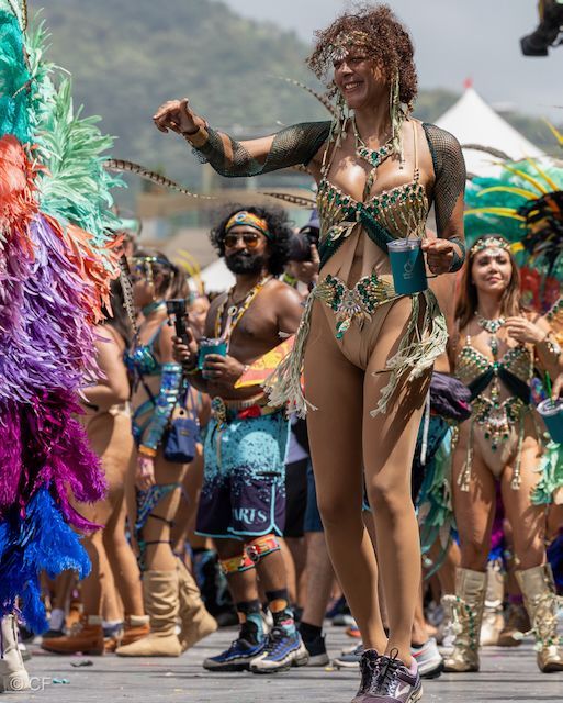 A woman in a bikini is dancing in a carnival parade.