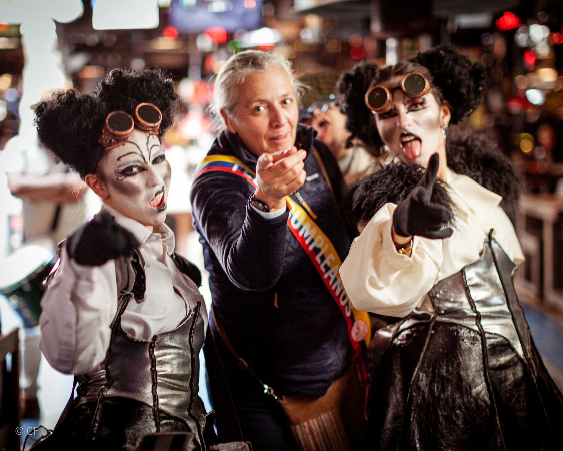 A woman is pointing at a group of women dressed in costumes
