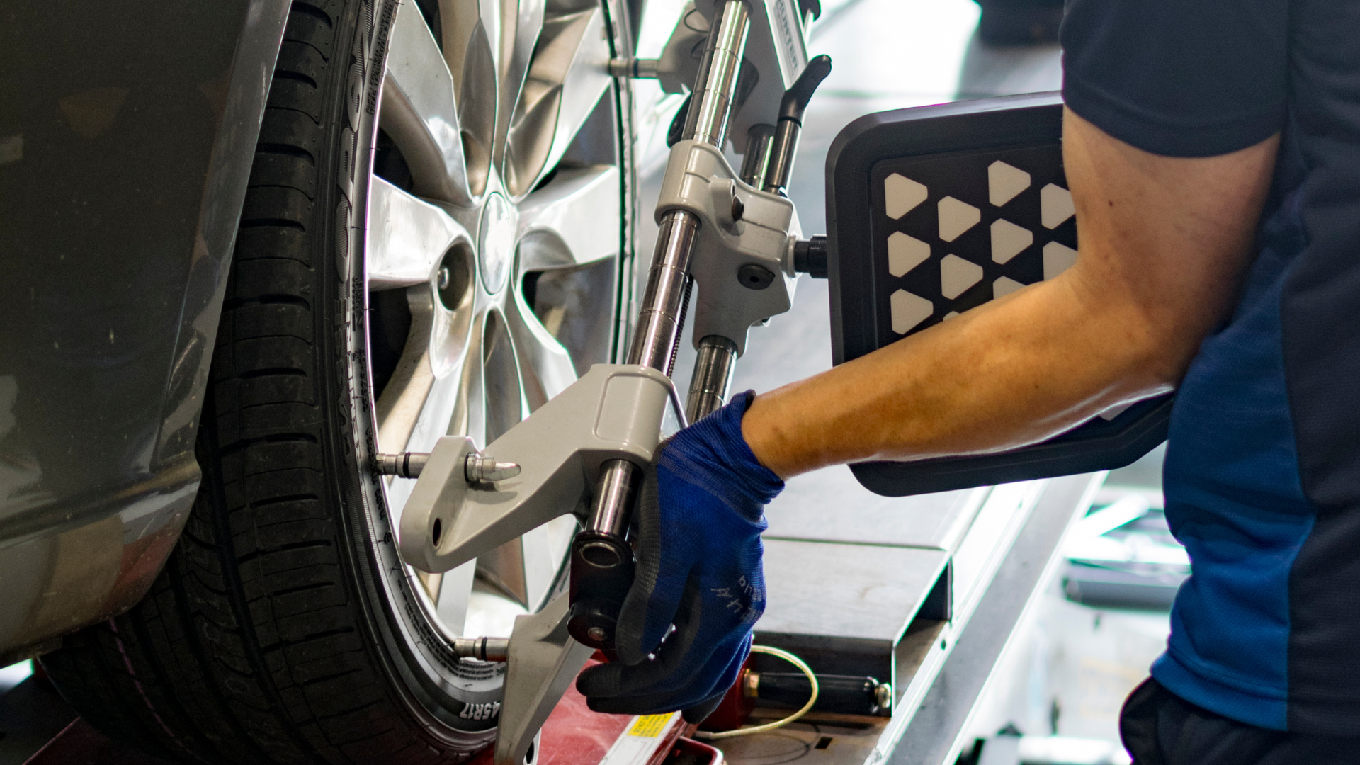 A man is working on a car wheel with a machine.