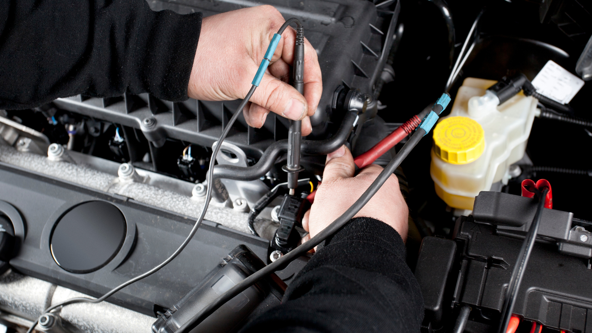 A person is working on the engine of a car.