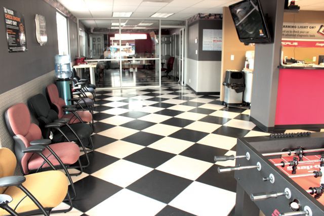 A room with a checkered floor and a foosball table