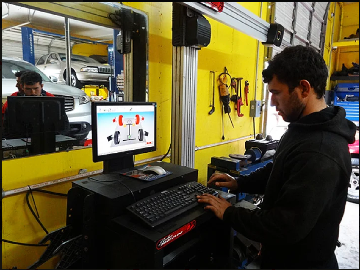 A man is working on a computer in a garage