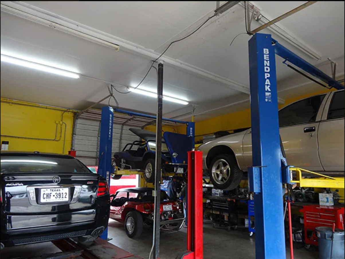 A car on a lift in a garage with a license plate that says sn 961