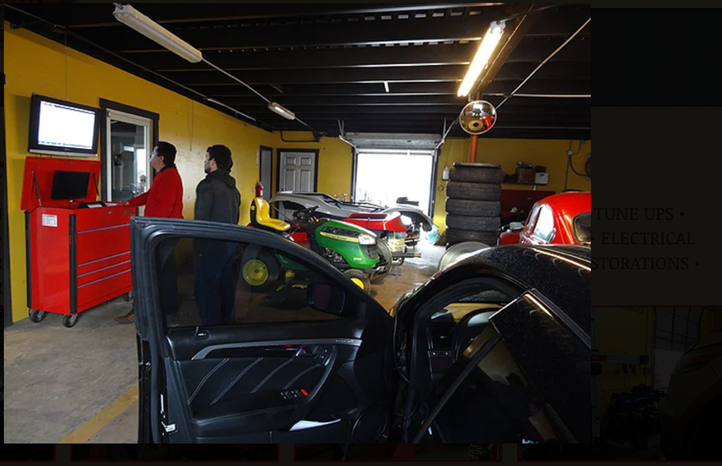 A group of people standing around a car in a garage