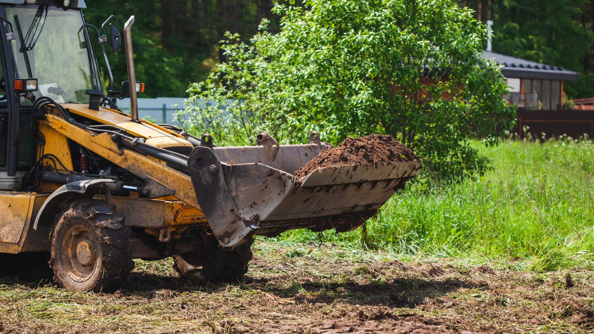 A bulldozer is moving dirt in a field.