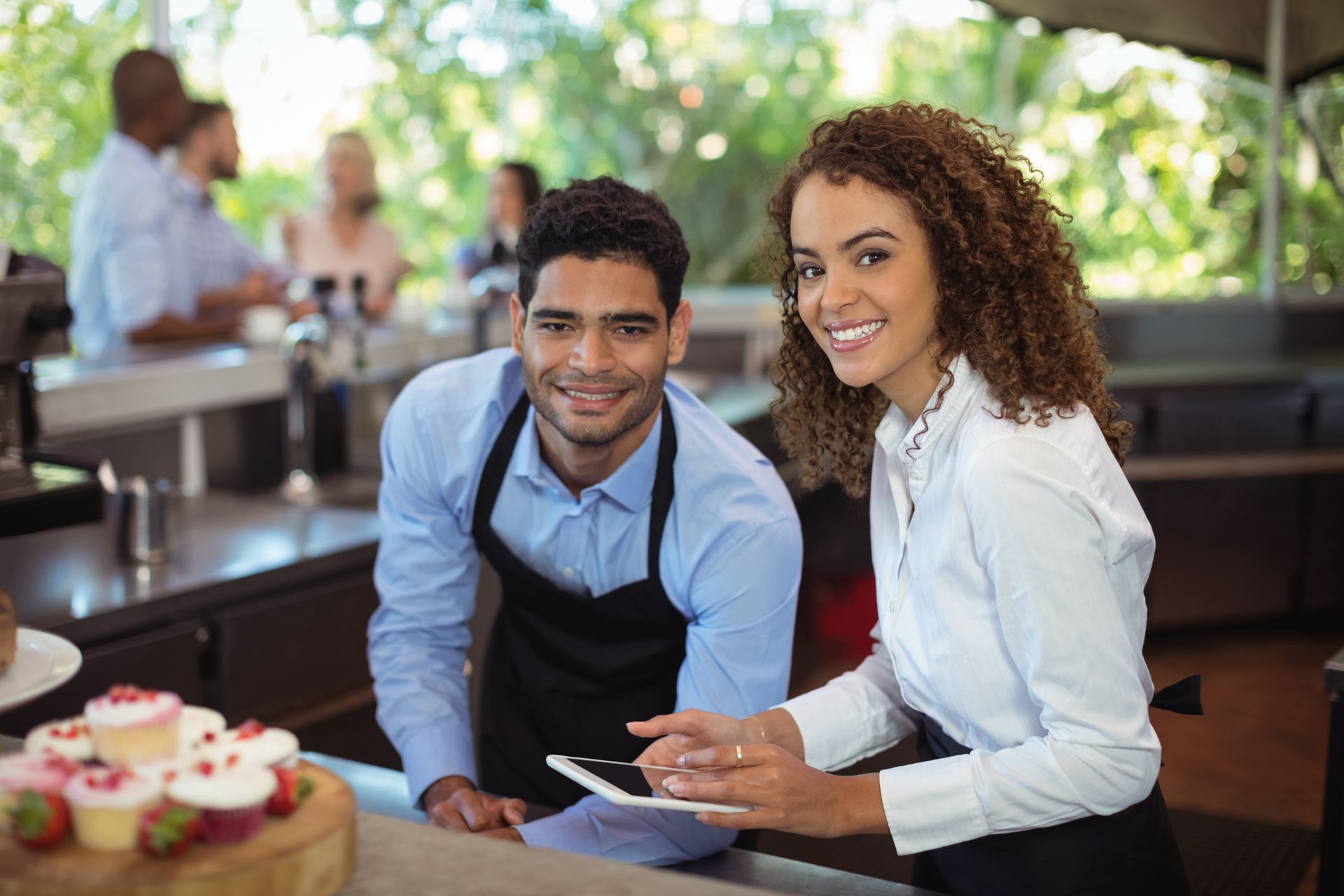 A man and a woman are standing next to each other in a restaurant.
