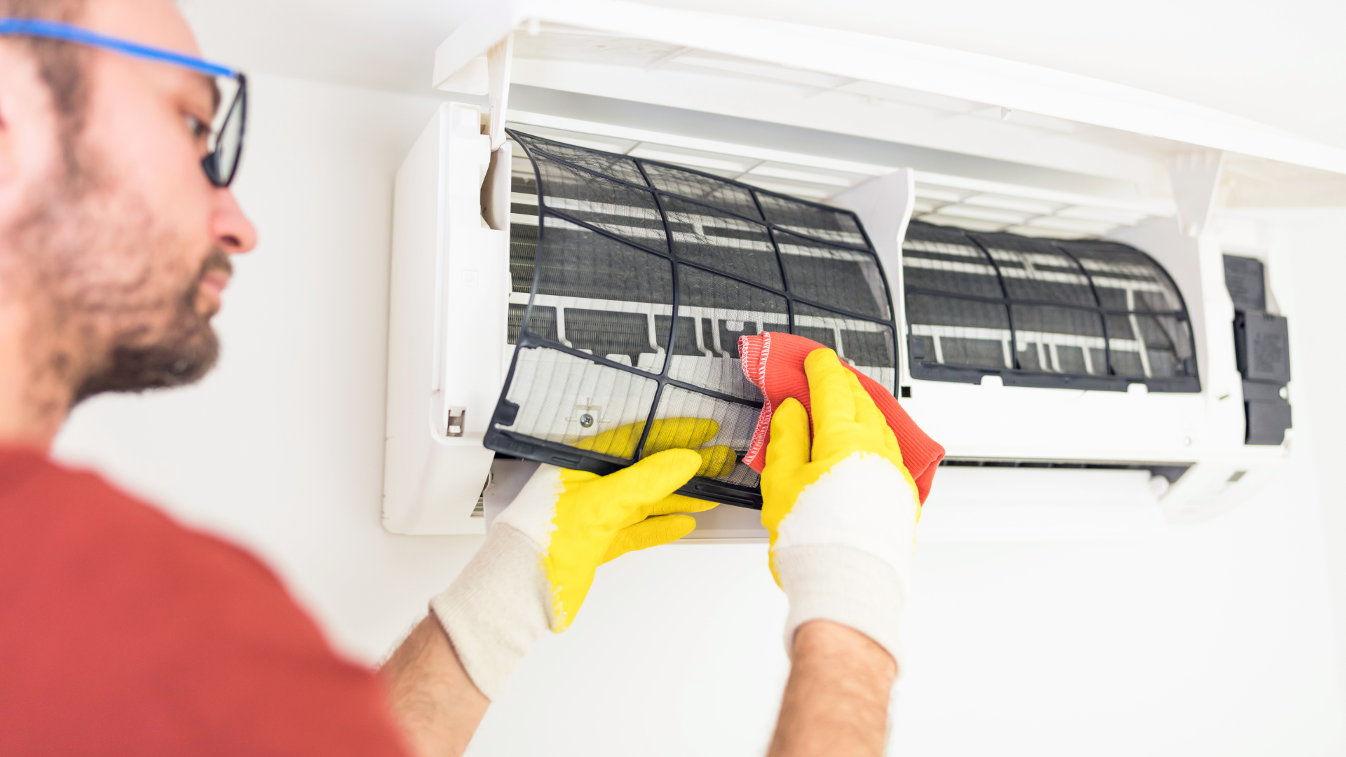 A person is holding a digital multimeter next to a water heater.
