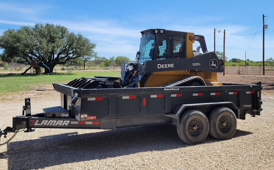 A dump truck is sitting on top of a trailer.