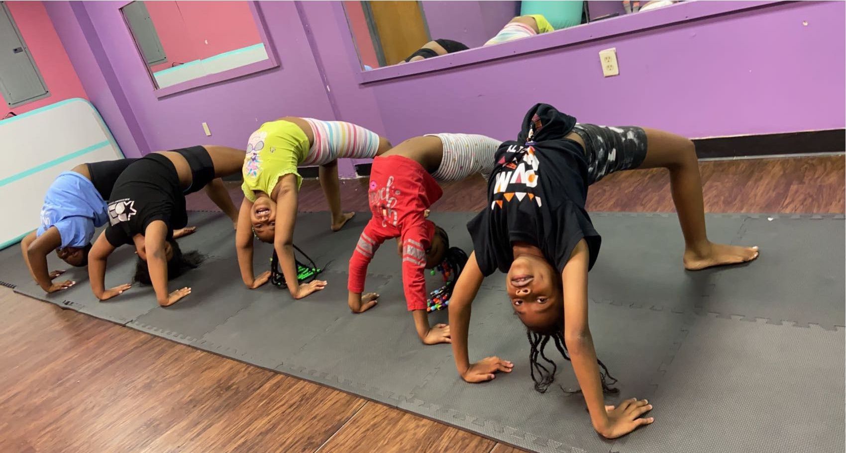 A group of young girls are doing handstands in a gym.