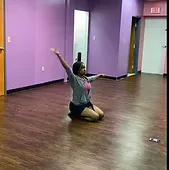 A woman is kneeling on the floor in a room with purple walls.
