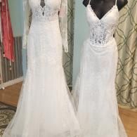 Two white lace bridal gowns displayed on mannequins in a shop setting.