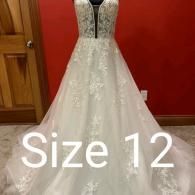 A white A-line wedding dress with floral lace detailing, a deep V-neck, and tulle skirt, labeled as size 12.