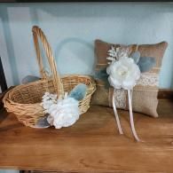 A rustic wedding basket and matching burlap ring bearer pillow, both decorated with white flowers and lace.