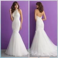 A woman models a white, floor-length mermaid-style wedding dress with a lace bodice and halter neckline from front and back.