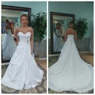 A person wearing a white, strapless, A-line wedding dress, shown from the front and back in a bridal shop.