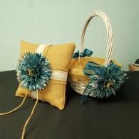 Mustard yellow wedding ring pillow and matching flower girl basket, both decorated with teal flowers and lace ribbon.