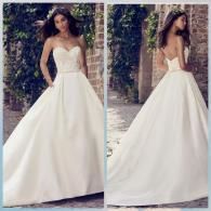 A side-by-side view of a strapless, floor-length white satin ballgown wedding dress with a full skirt and open back.