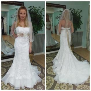 A woman in a strapless white lace wedding dress with a tan sash and veil, standing in a bridal shop, shown front and back.