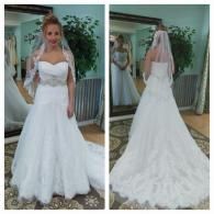 A bride wears a strapless white wedding gown and veil, shown from the front and back in a bridal shop mirror.