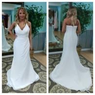 A split view of a person modeling a floor-length, strapless, white mermaid wedding dress in a boutique setting.