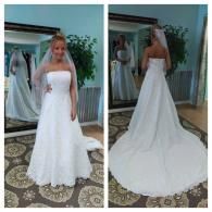 A bride wearing a strapless, white lace-overlay gown with a train and veil, shown from the front and back in a boutique.