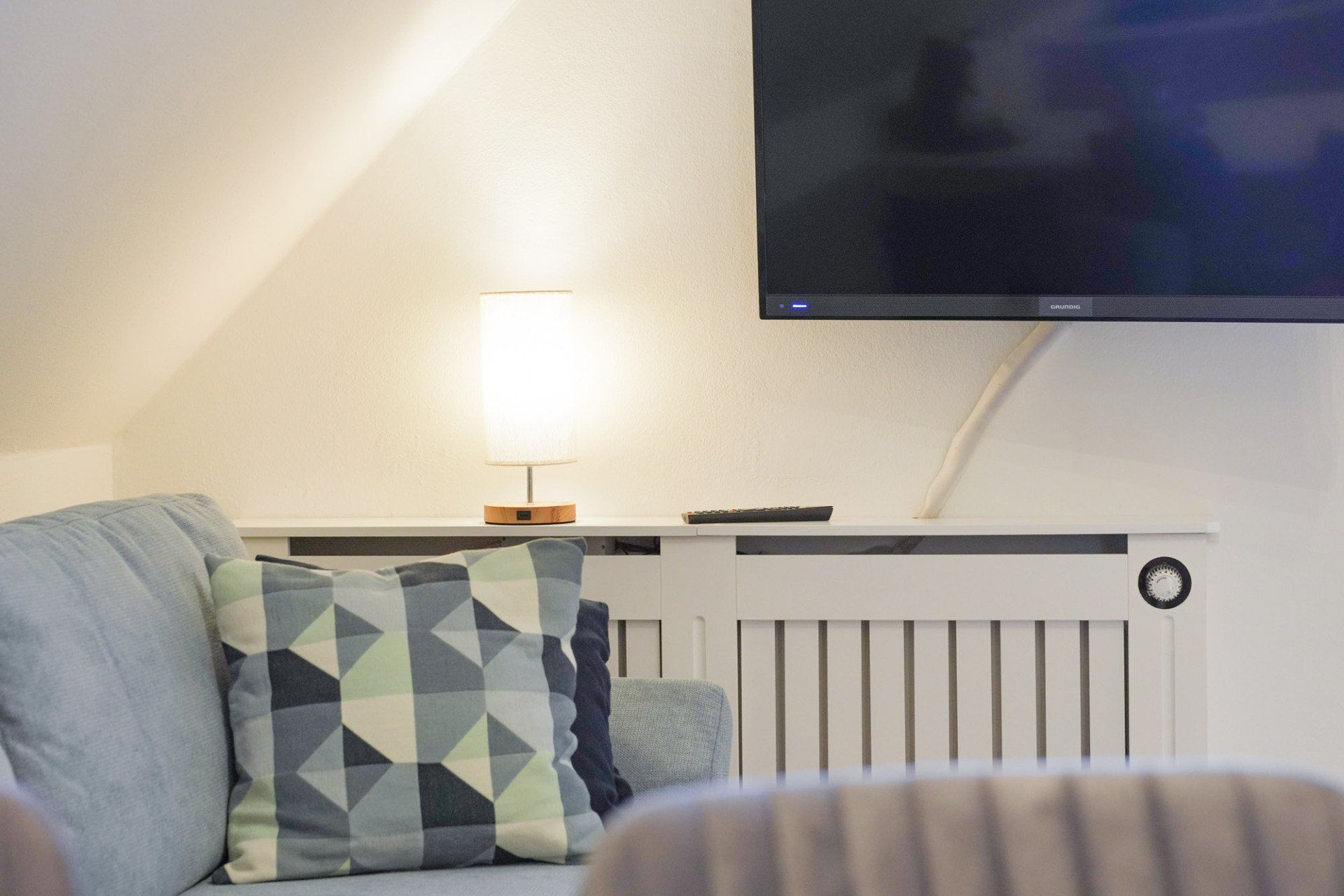 Sofa, Sofakissen, Kommodenlampe und Fernseher