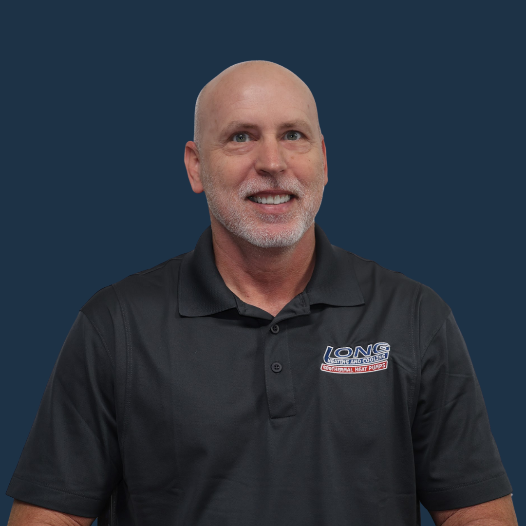 Bald man in a black polo shirt smiles at the camera against a blue backdrop.