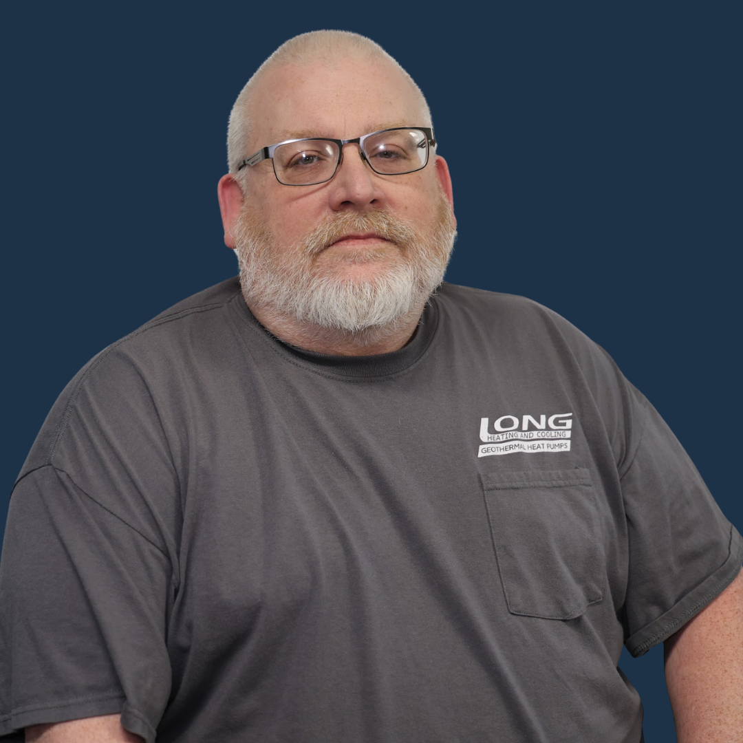 Bald man with glasses and beard wearing a gray shirt with the 