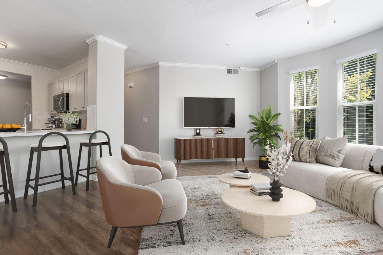 Open-concept living room with sofa, two chairs, coffee tables, and a kitchen bar.