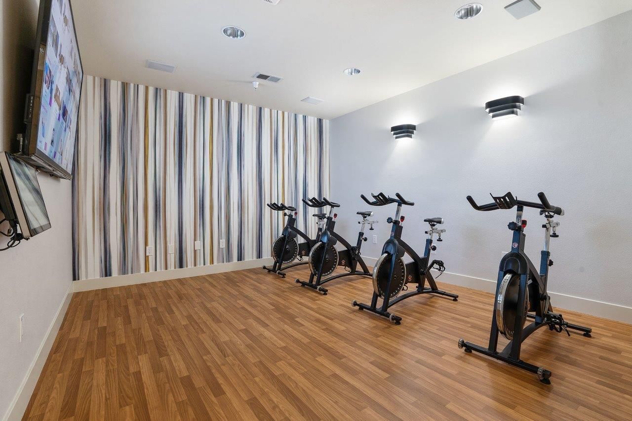 Indoor gym with several stationary bikes in a modern fitness space.