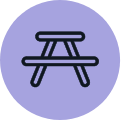 Picnic table icon in black on a light purple background.