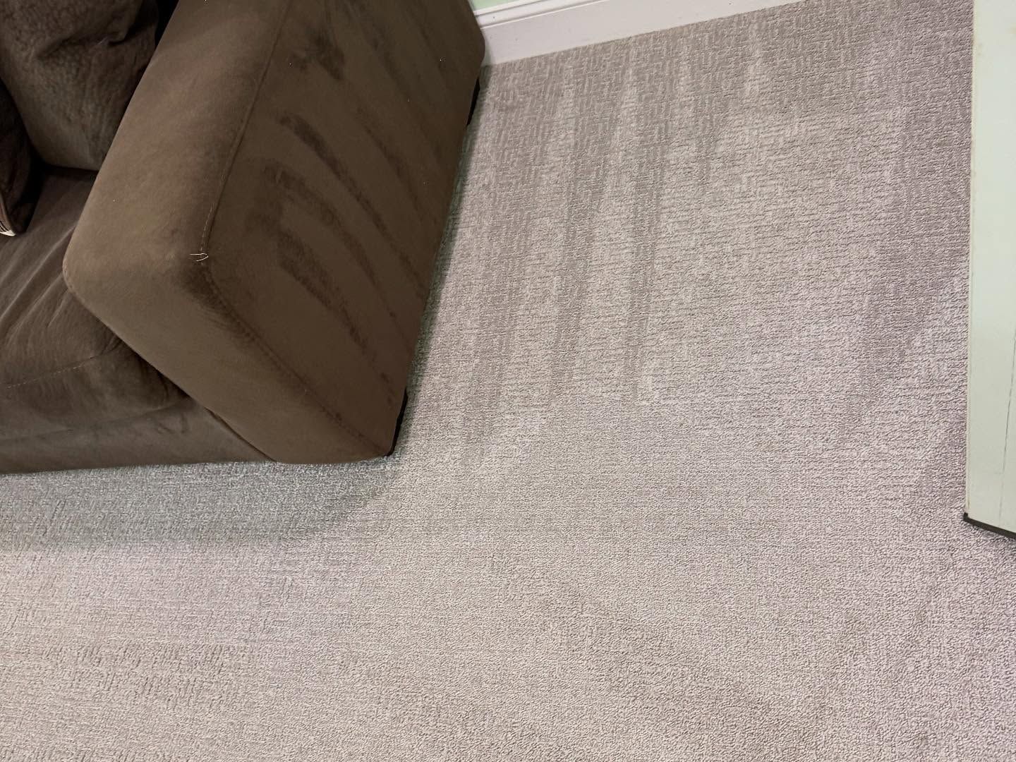 A living room with a couch and a rug on the floor.