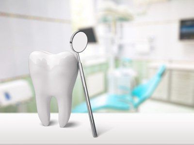 modellino di un dente con appoggiato specchietto del dentista