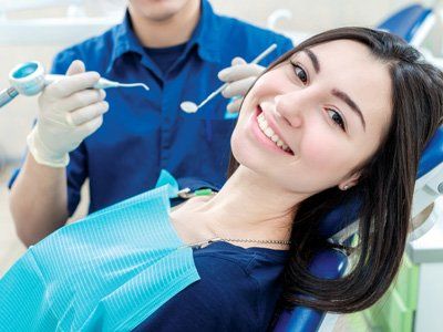 paziente sorride durante una visita dentistica