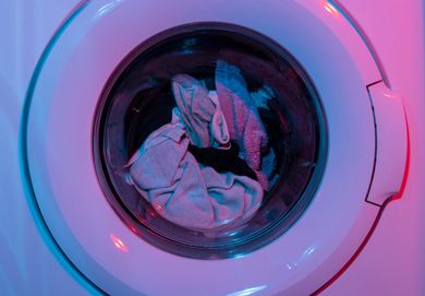A close up of a washing machine with clothes in it.
