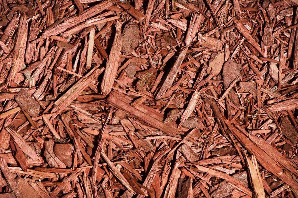 Reddish-brown Wood Chip Mulch — Summit Tree Services in Glenwood, QLD