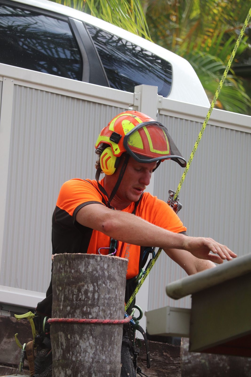 Arborist in Orange Safety Gear Preparing Equipment Outdoors — Summit Tree Services in Maleny, QLD
