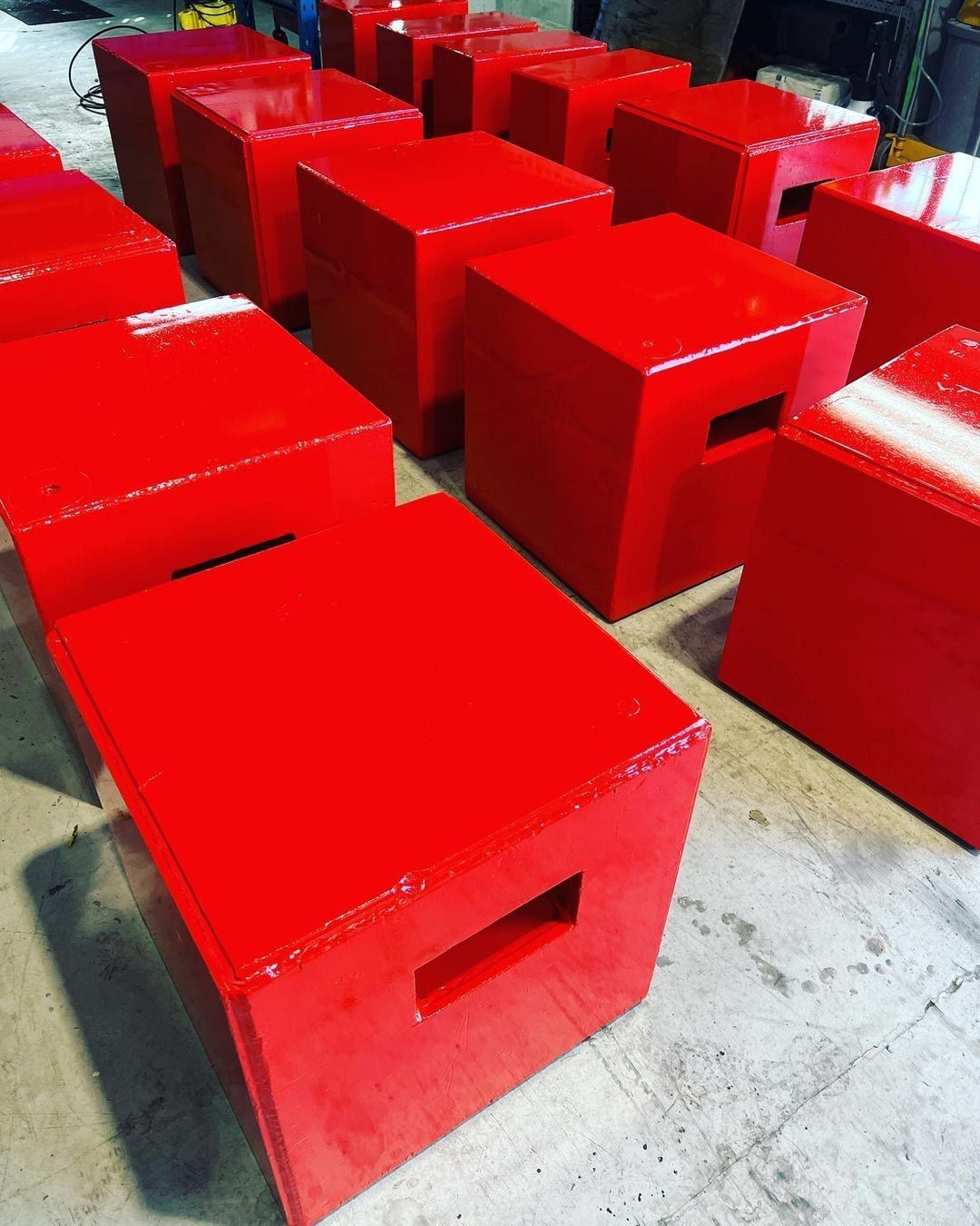 A bunch of red boxes are lined up on the floor