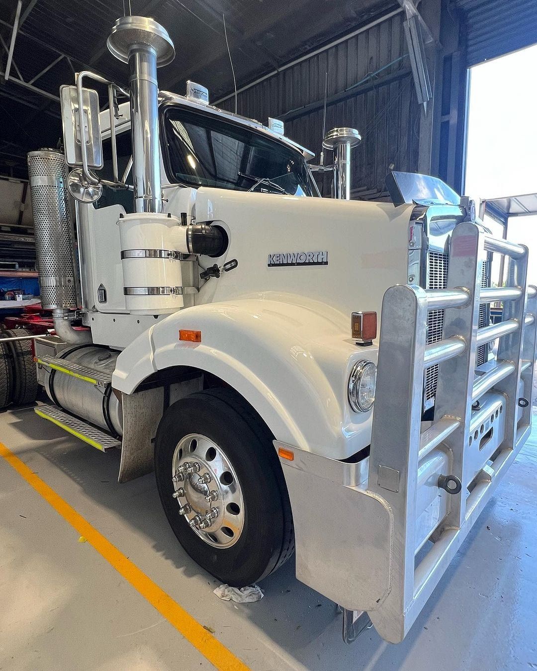 a white semi truck is parked in a garage .