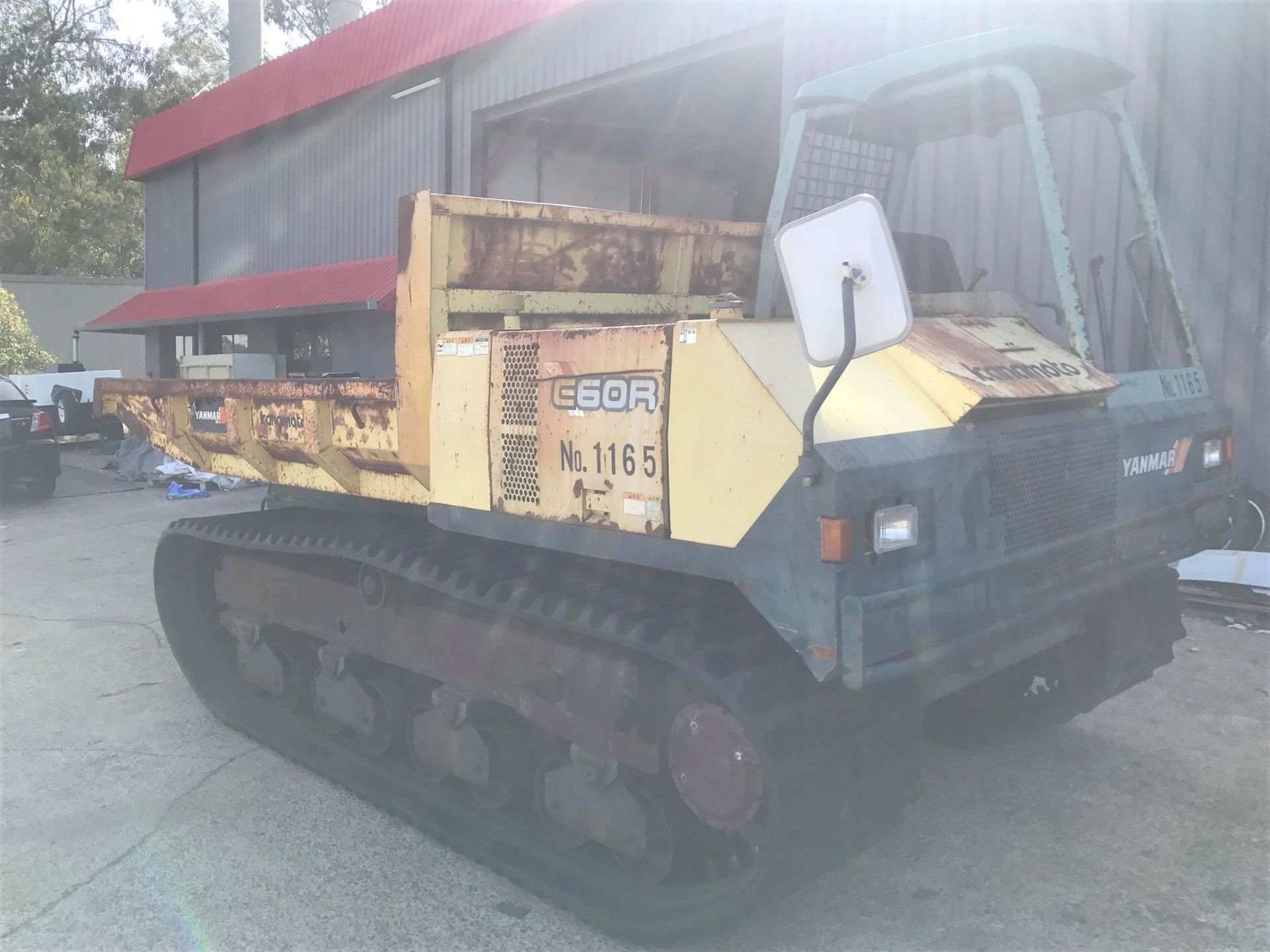 A yellow dump truck is parked in front of a building